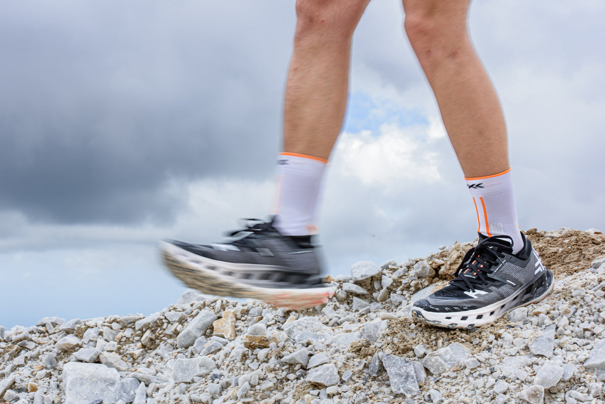Foto del produttore che mostra capi tecnici X-BIONIC e scarpe da trail TerraSkin disposti per evidenziare la struttura ingegnerizzata dei tessuti.